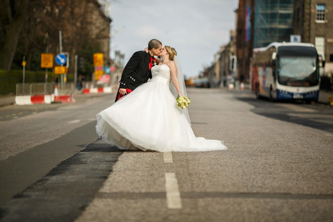 bride and groom kissing on Queen Street in Edinburgh