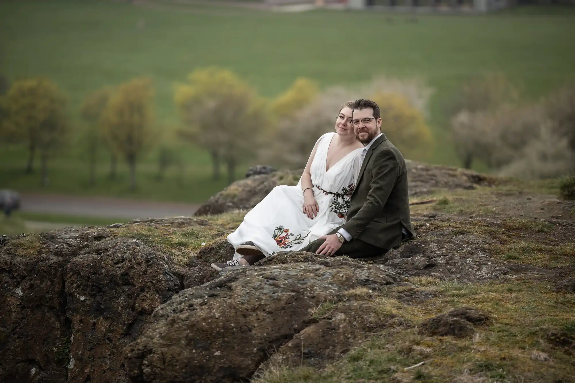 newlyweds sat on rocky outcrop