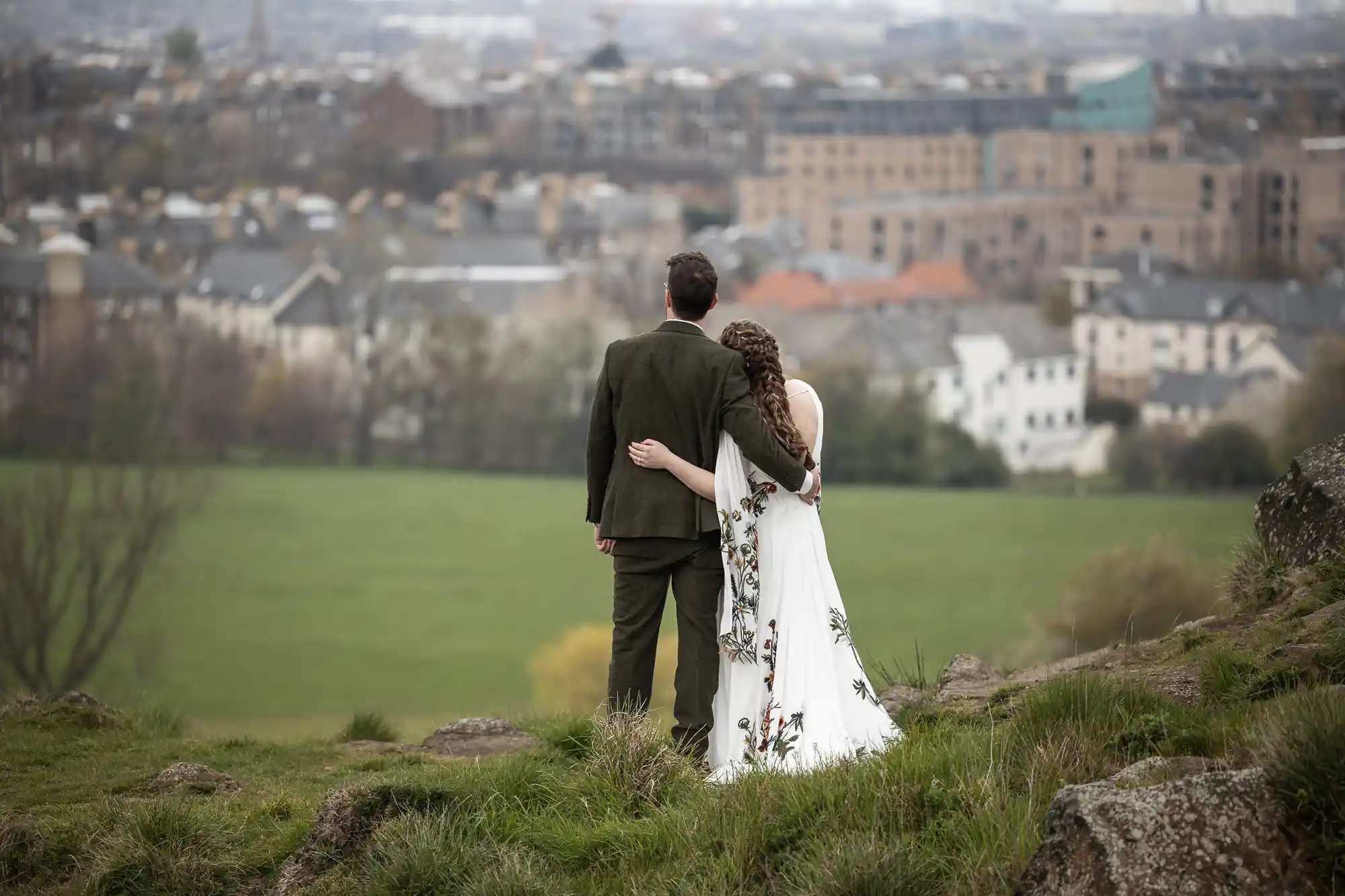 newlyweds embrace looking out over city