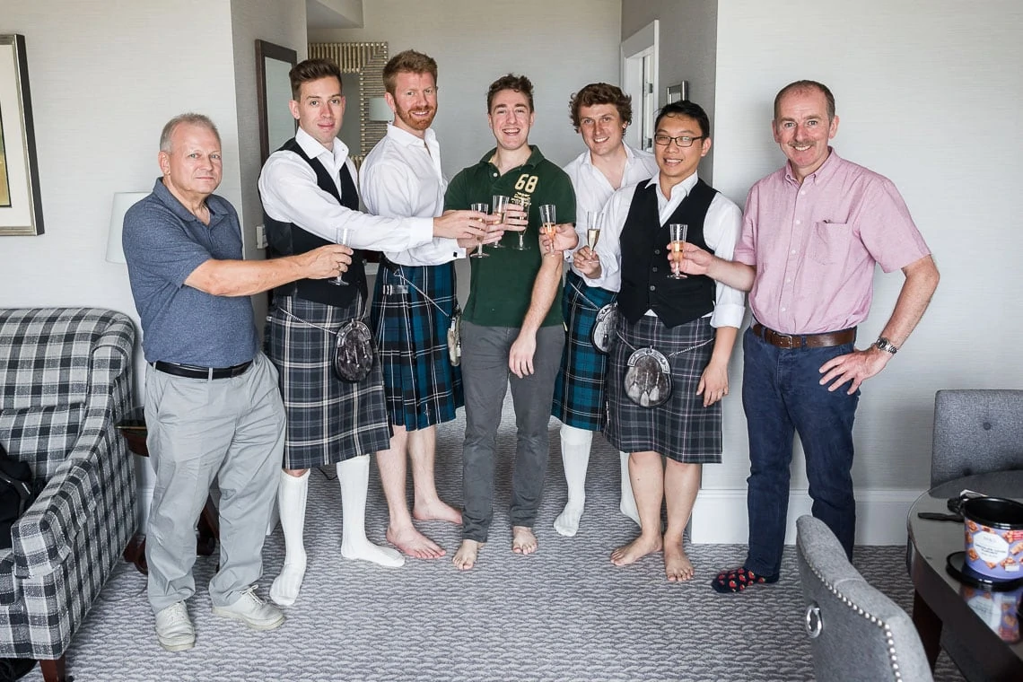groom, groomsmen and fathers raising a toast