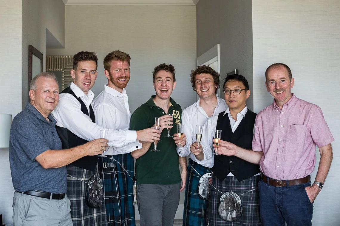 groom, groomsmen and fathers raising a toast