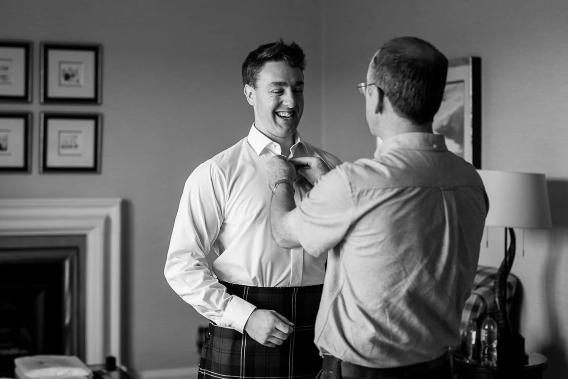 groom tie fitting with father