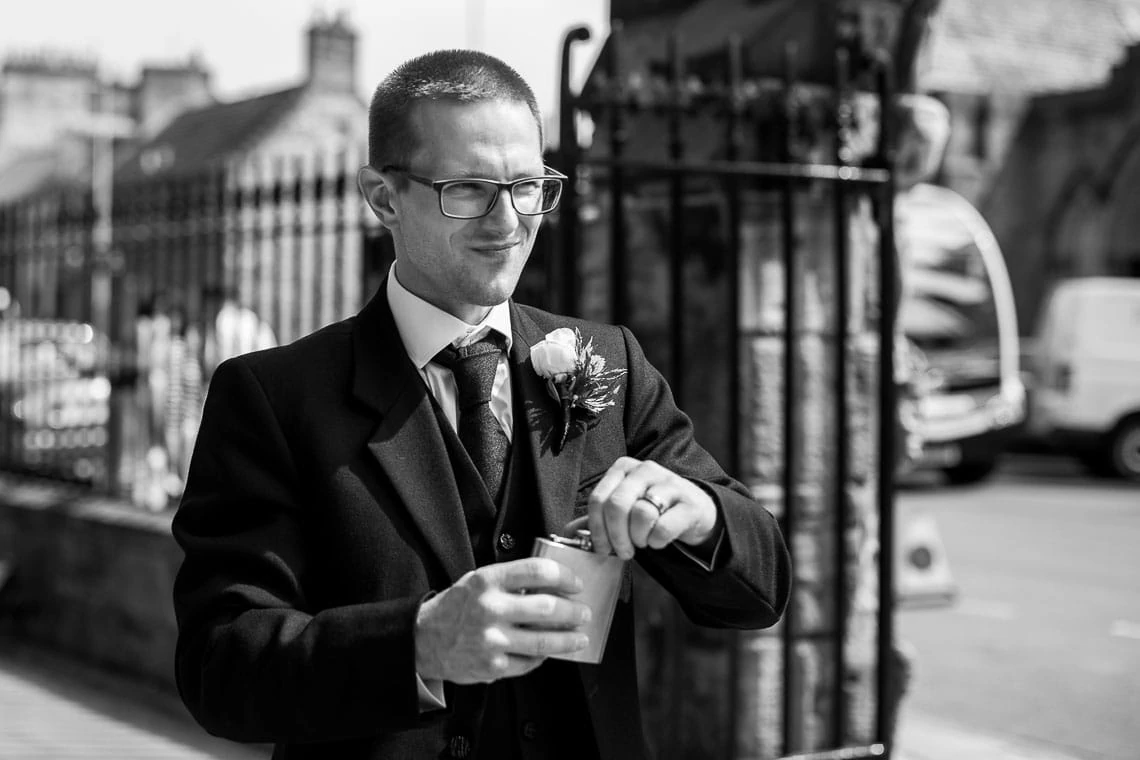 groomsman about to take a swig of whisky from a hip flask