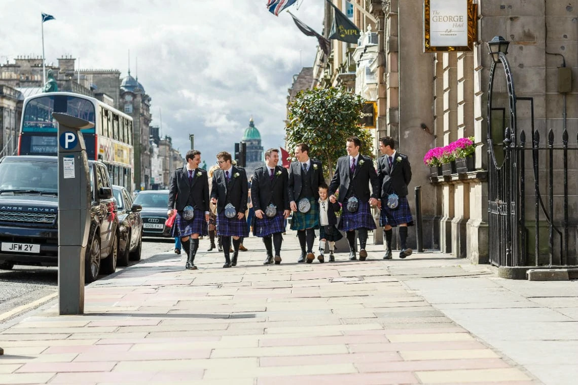 groom and groomsmen wearing kilts walking along George Street
