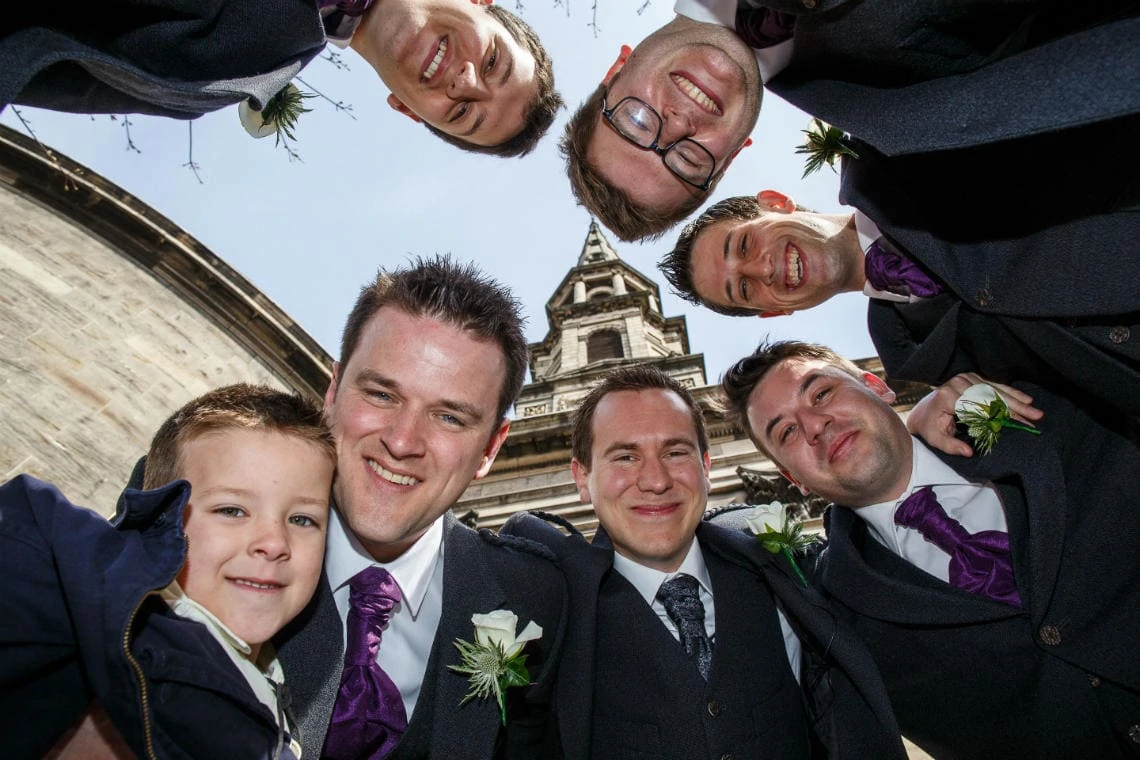 groom and the boys group photo with St Andrew's and St George's West Church of Scotland in the background