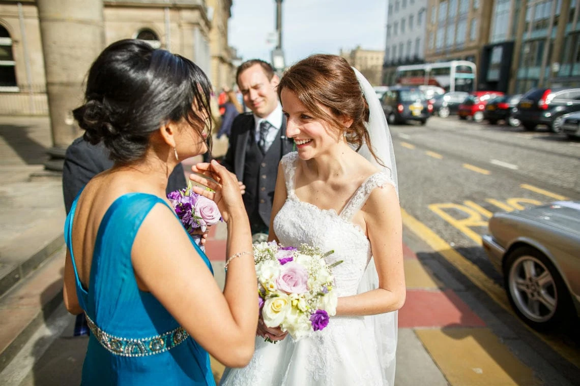 bridesmaid congratulates the bride outside the church on George Street