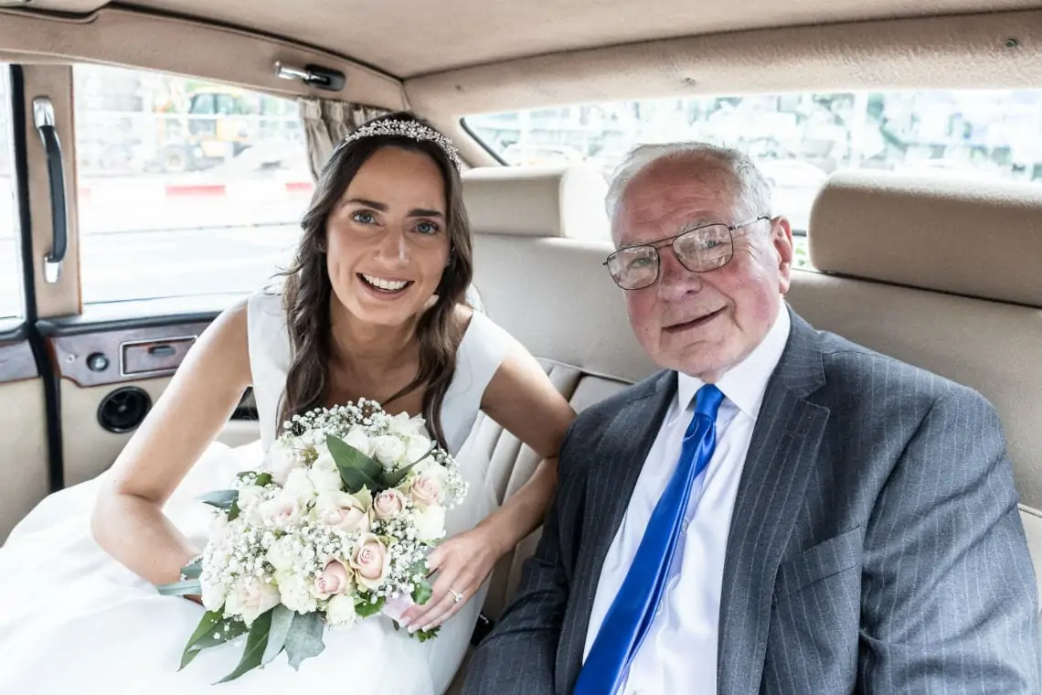 bride and father of the bride inside wedding car
