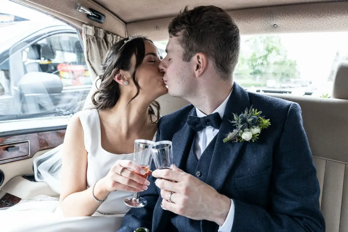 Newlyweds kissing in wedding car