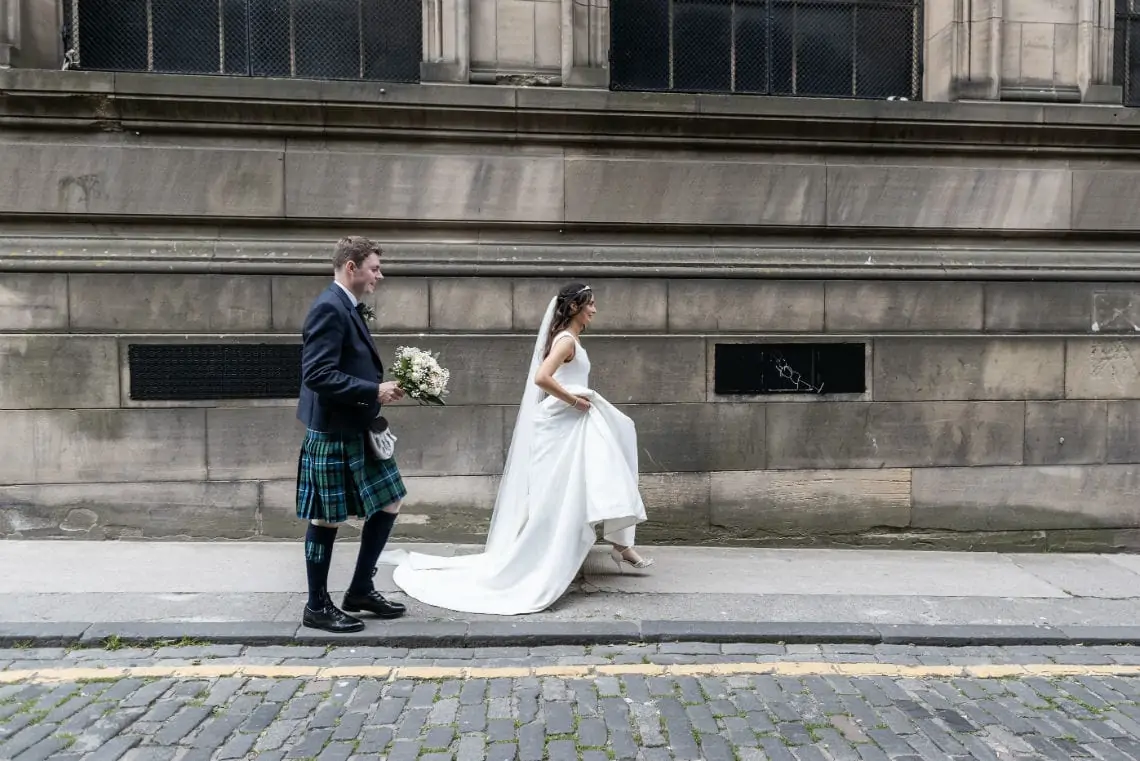 Newlyweds walking up a street in Edinburgh