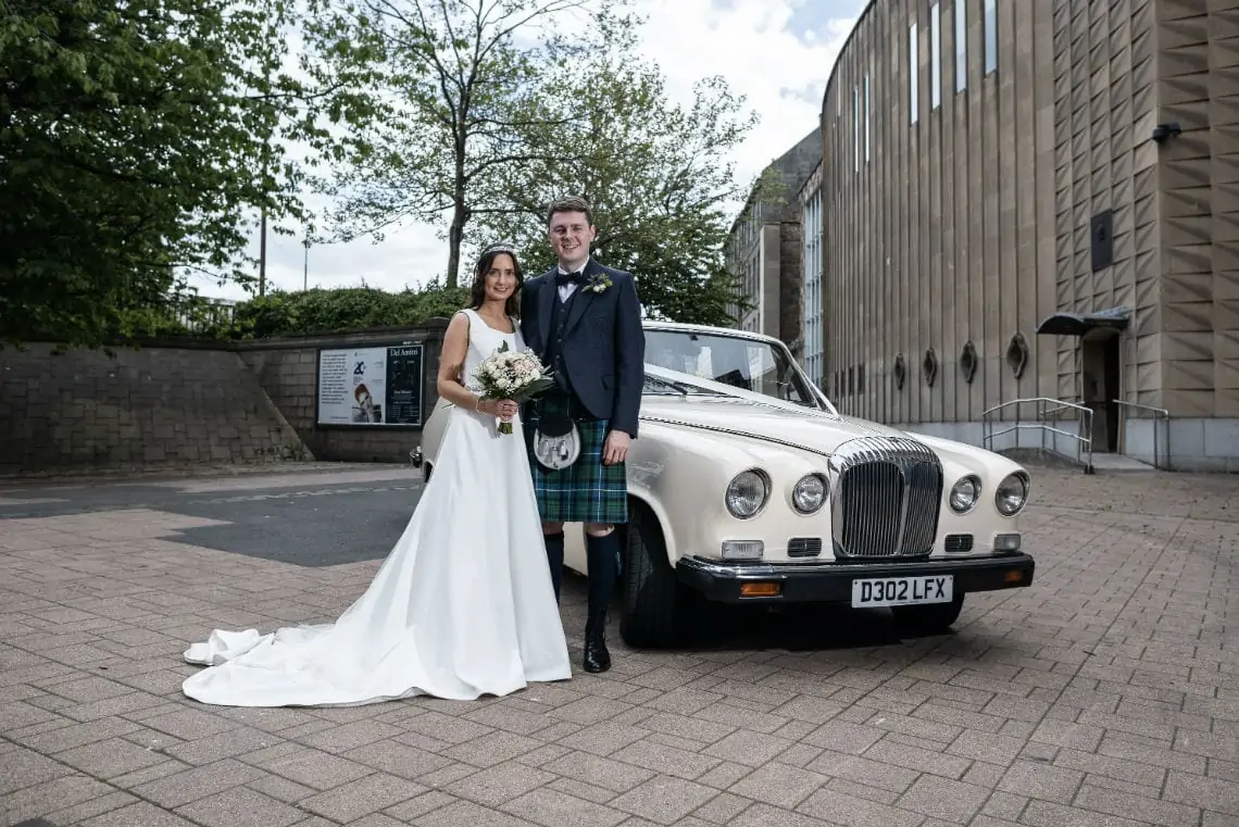 Bride and Groom in front of wedding car