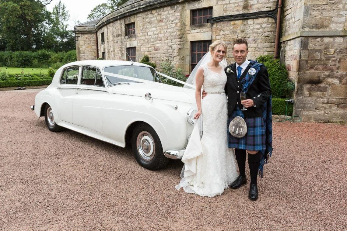 Stables Ballroom newlyweds posing with Rolls Royce wedding car
