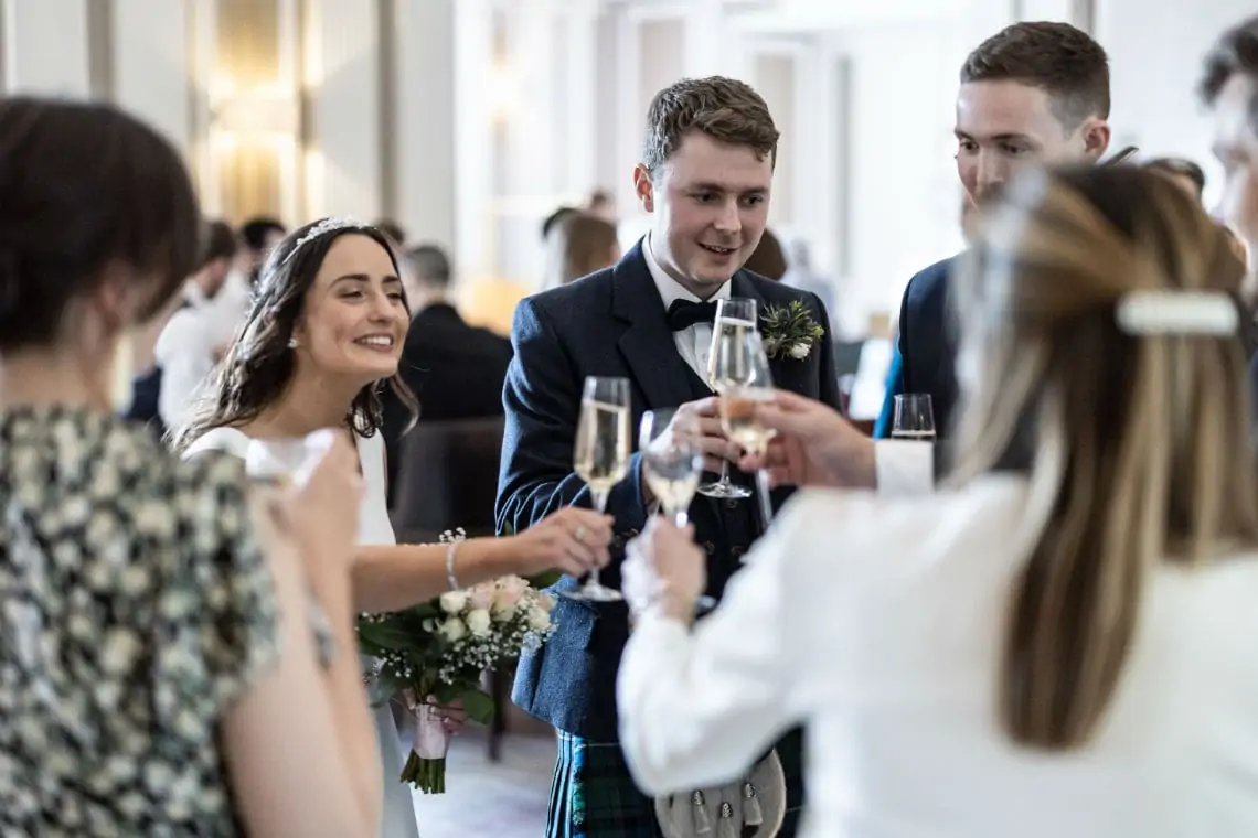 Bride and Groom do a cheers with guests