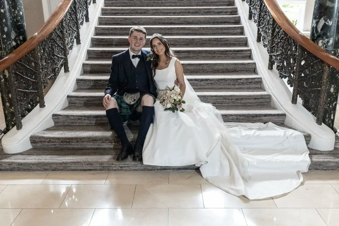 Bride and Groom sitting on the staircase at the hotel