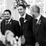 groomsmen laughing as they wait for the arrival of the bride in the Kings Hall