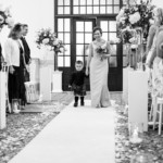 bridesmaid and page boy walking up the aisle in the Kings Hall`