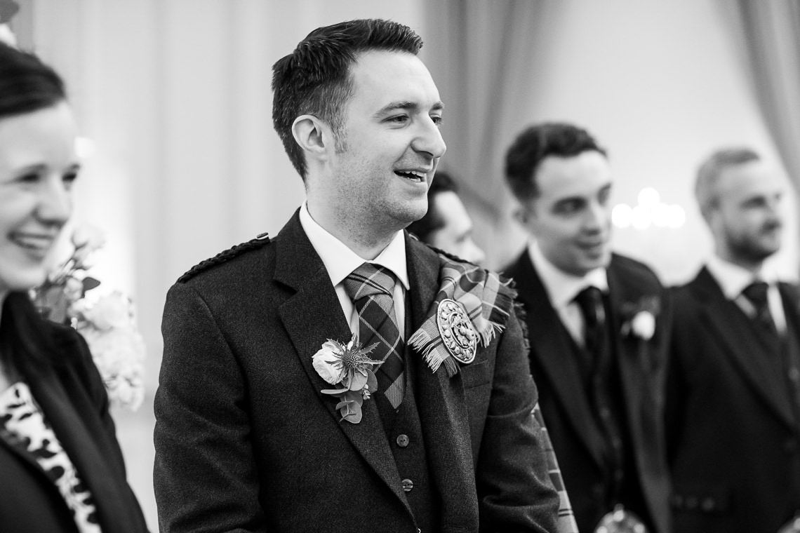 groom happy to see the arrival of the bride in the Kings Hall