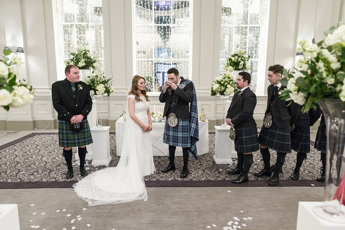 groom drinks whisky from a quaich