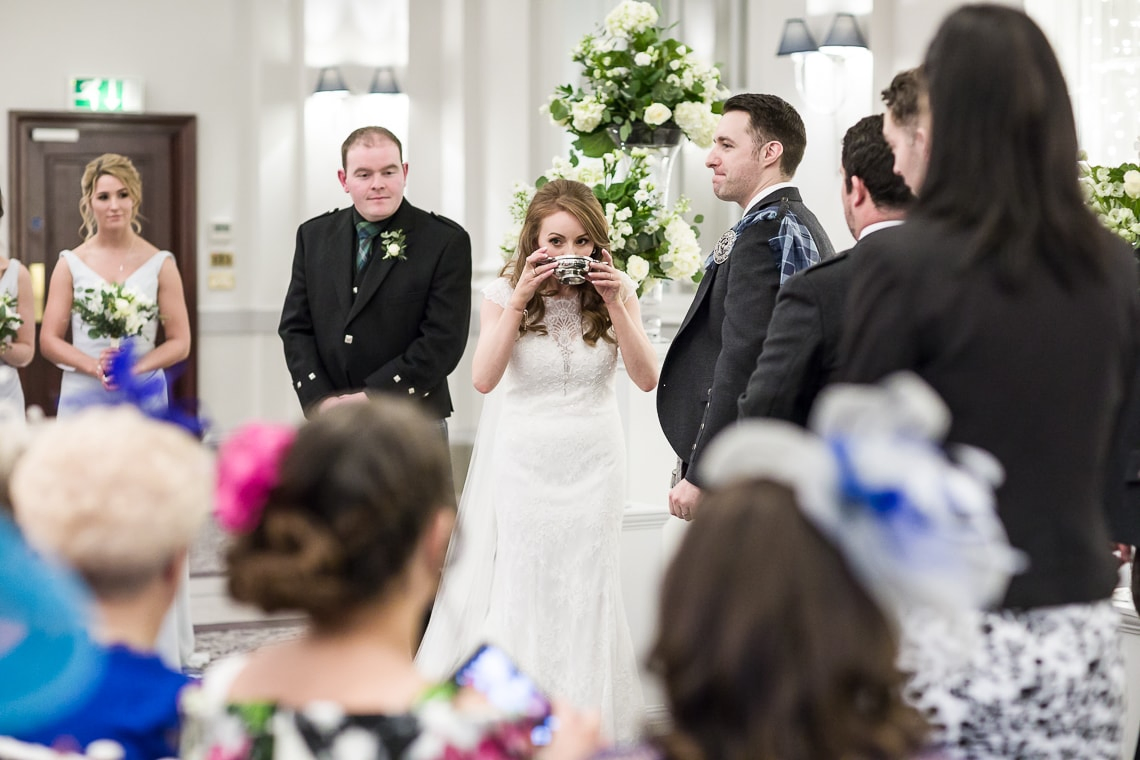 bride drinks whisky from a quaich
