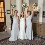 bride and bridesmaid punching the air outside the King's Hall