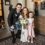 newlyweds and little girl outside the King's Hall