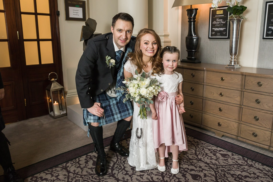 newlyweds and little girl outside the King's Hall