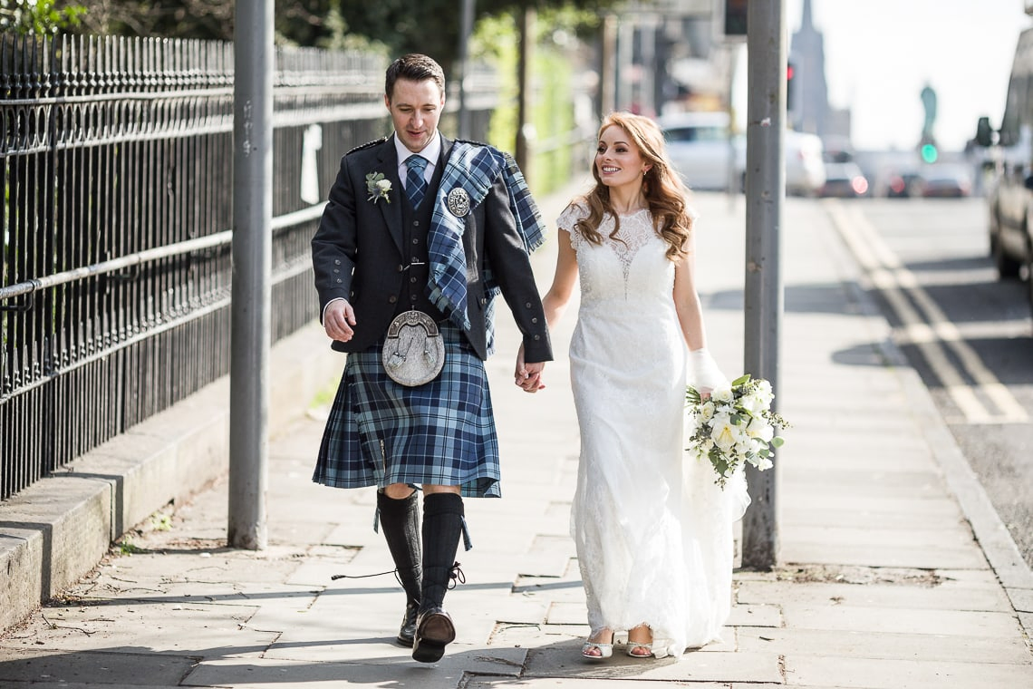 newlyweds walking along Queen Street Gardens East