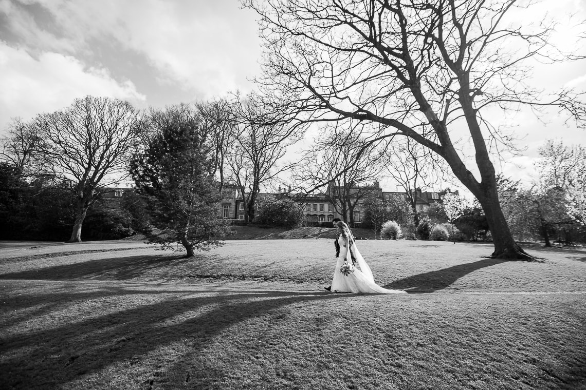 newlyweds walking in Queen Street Gardens view from the side