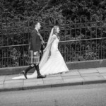 newlyweds walking up Queen Street Gardens East viewed from the opposite side of the road