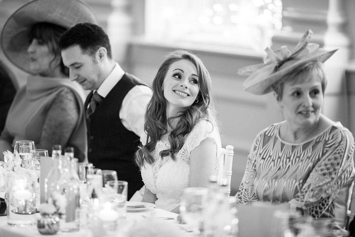 bride smiles during her brother's speech in the King's Hall