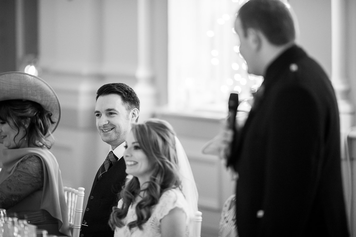 bride smiles during her brother's speech in the King's Hall