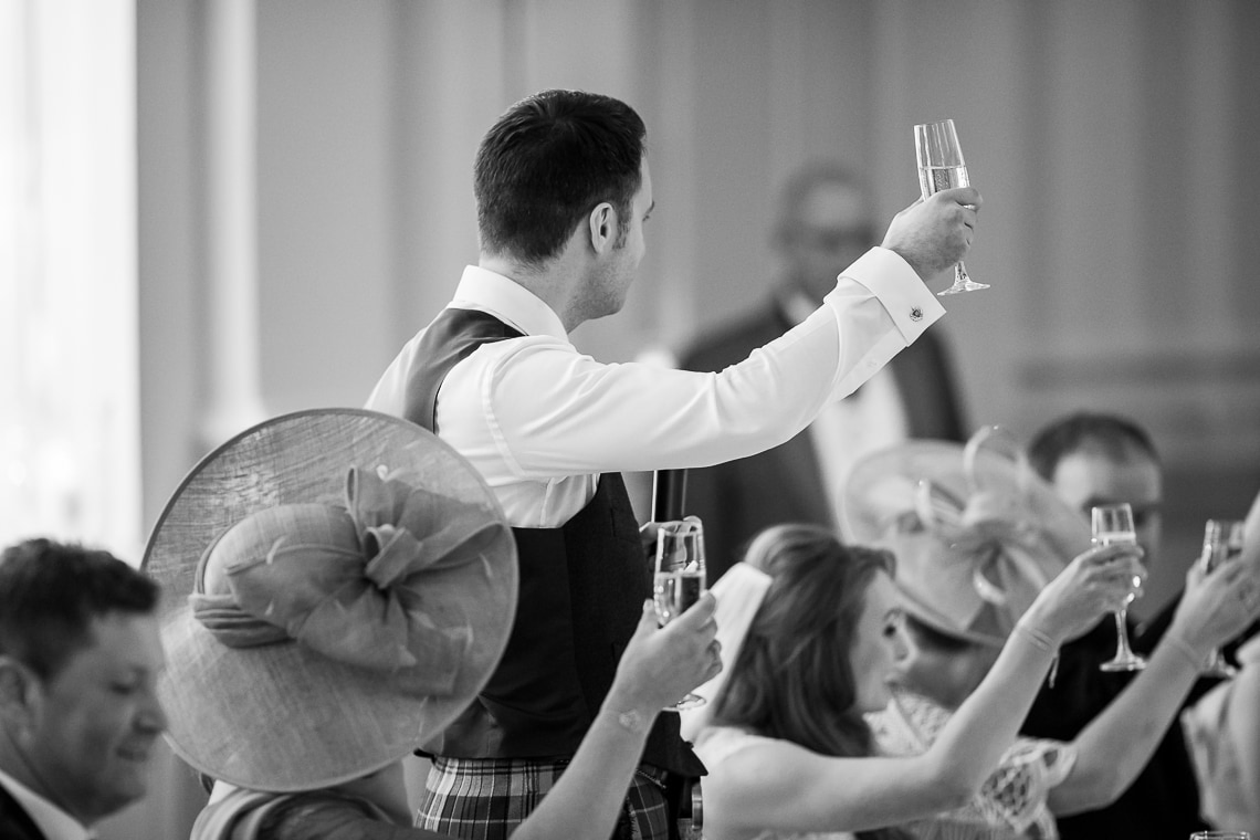 groom raises a toast in the King's Hall
