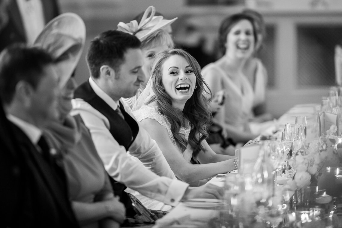 bride laughing during the best men speech in the King's Hall