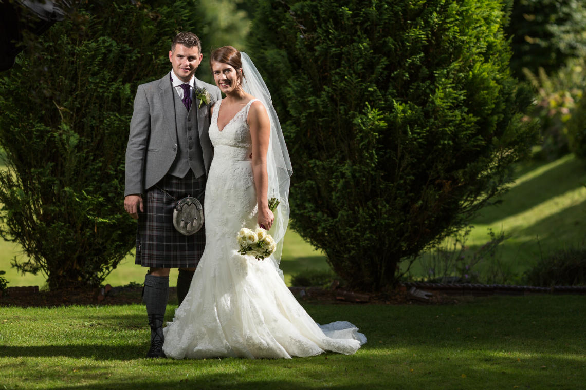 newlyweds on the lawn looking at the camera