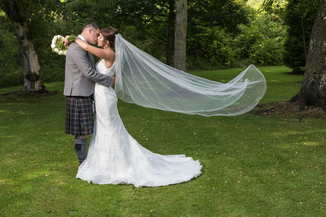 newlyweds with bridal veil floating