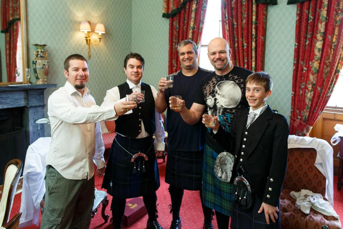 groom and groomsmen preparations and raising a toast in The Dalwolsey Suite
