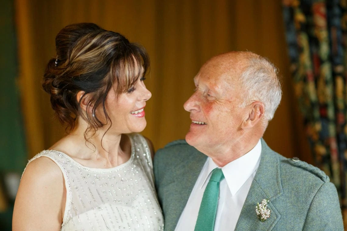 bride and her father smiling at each other