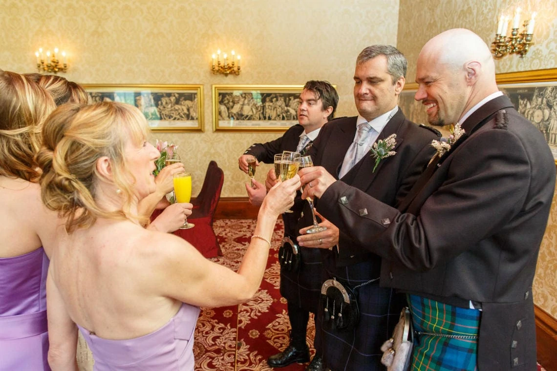 wedding party raise a toast to the newlyweds in the Sir Alexander Room