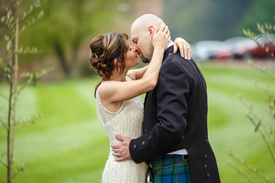 newlyweds embrace on the lawn in front of the castle