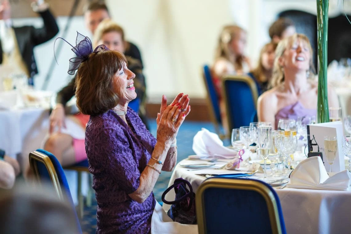 female guest laughing and clapping during father of the bride speech in the Ramsay Suite