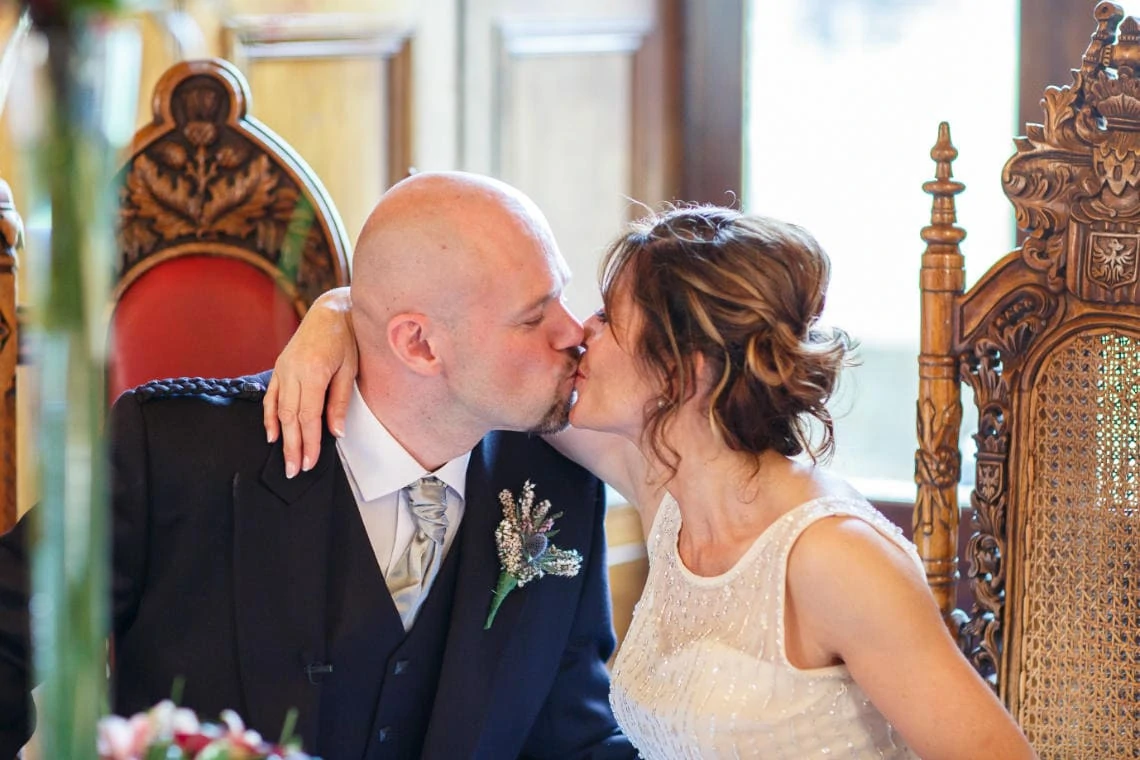 bride and groom kiss at the end of the groom's speech in the Ramsay Suite