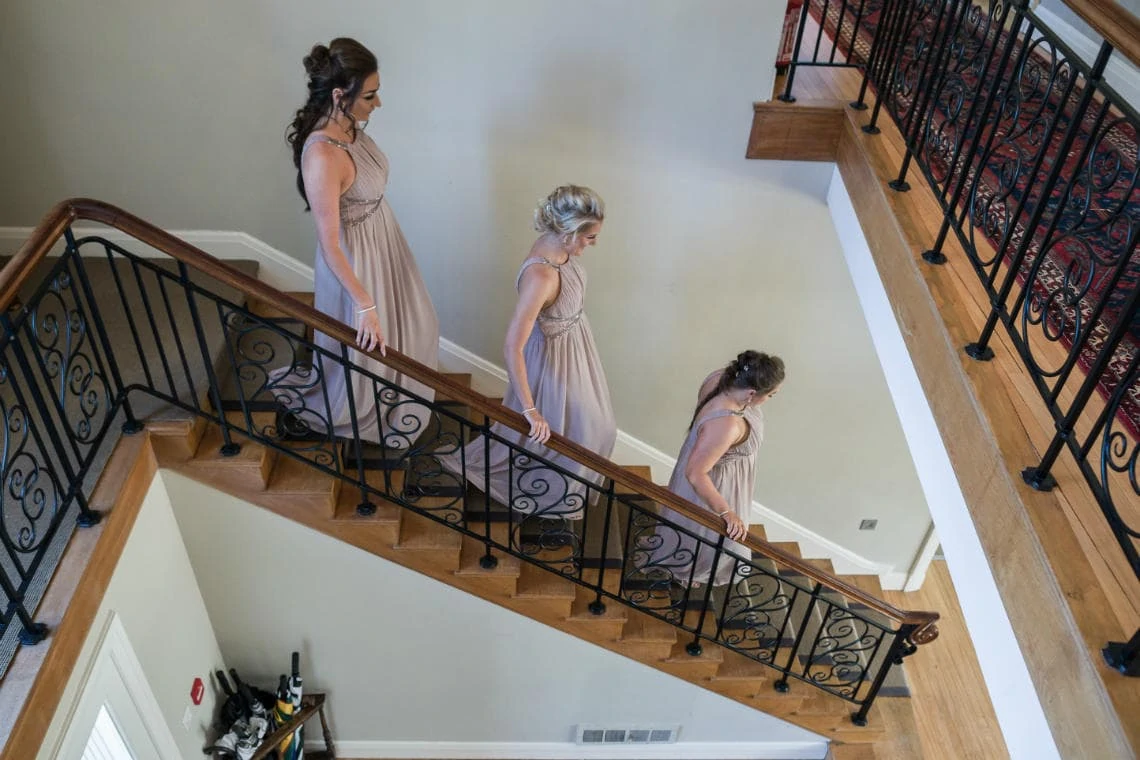 bridesmaids walking down staircase in house