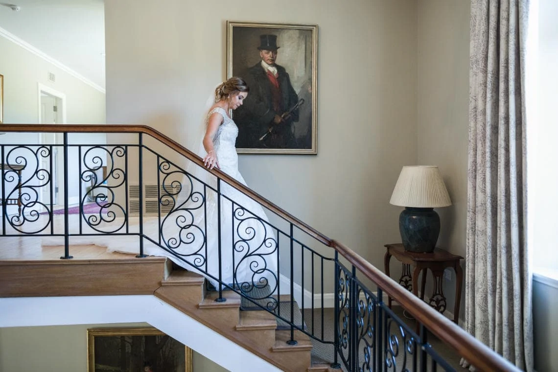 bride walking down staircase in house