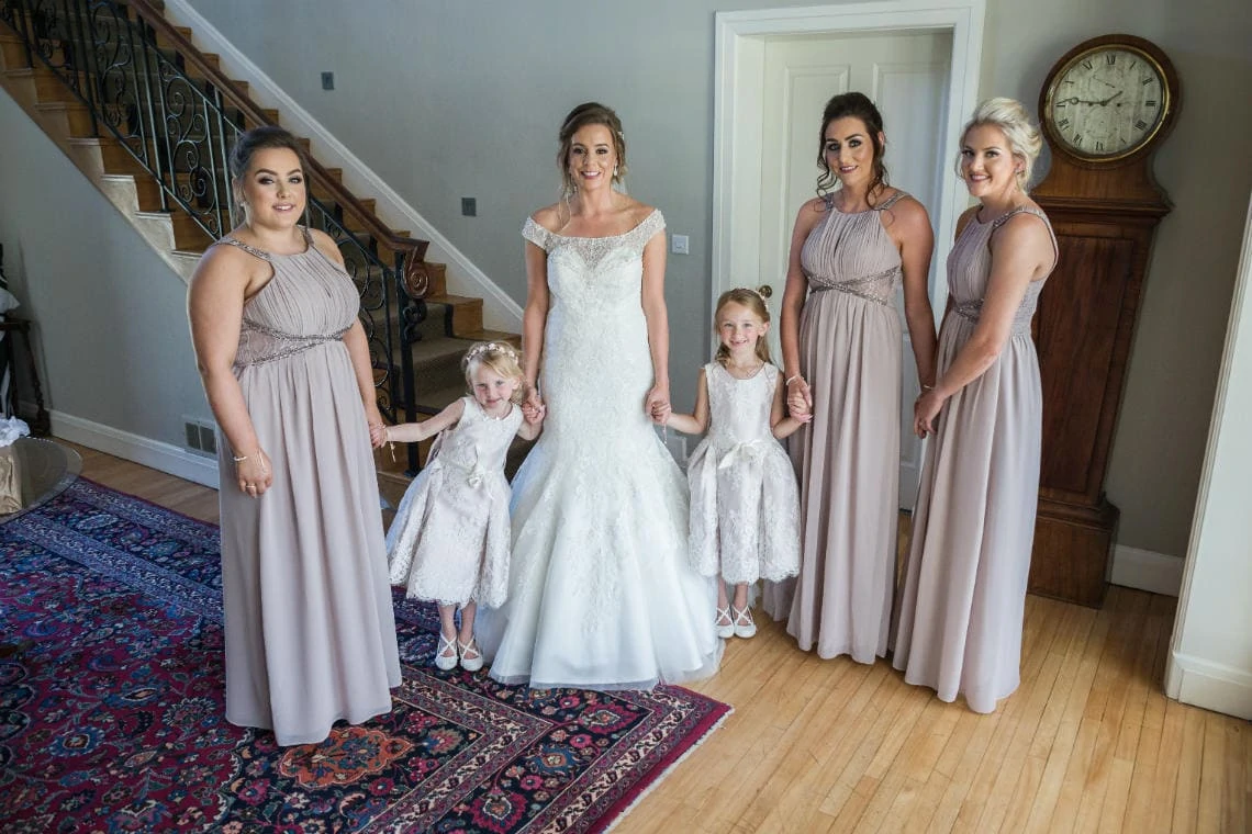 bride and bridesmaids with flower girls in house
