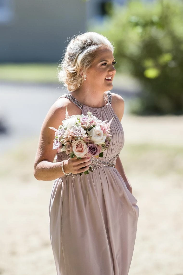 bridesmaid carrying flowers making her way to the church