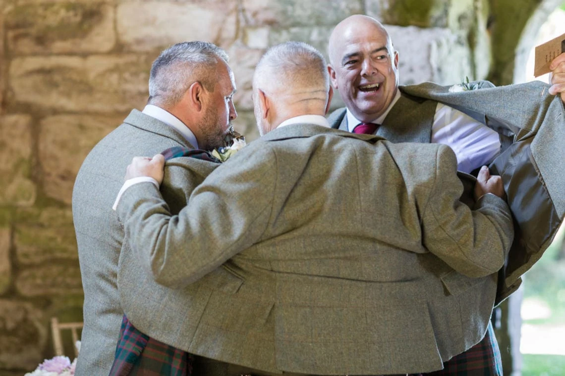 groomsmen share a drink in church at the alter