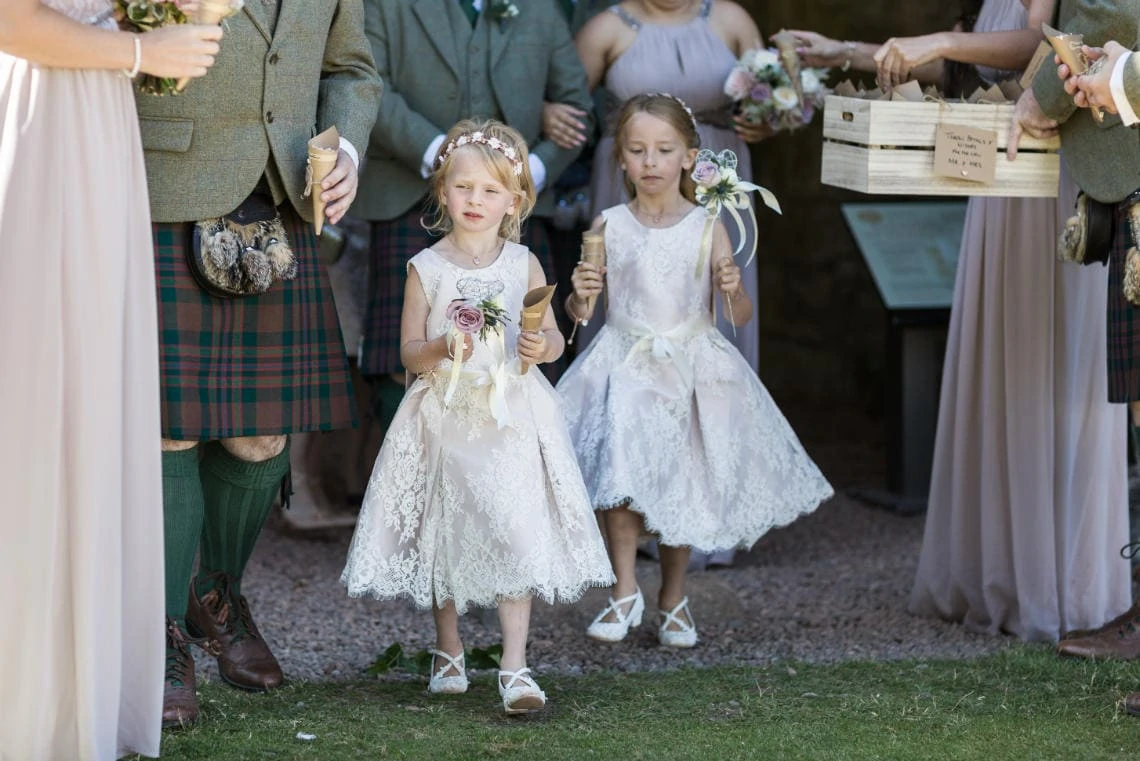 flower girls carry confetti cones outside