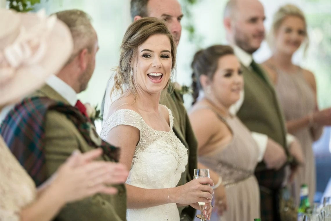 photo of bride laughing as she arrives at the top table