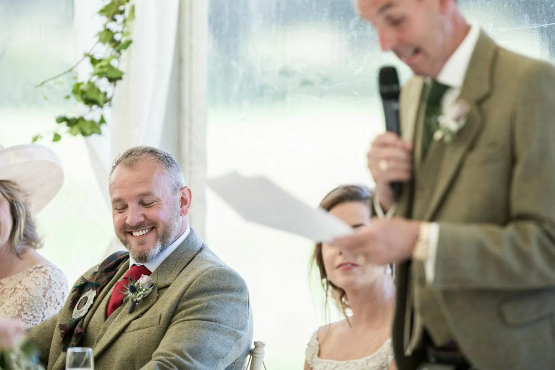 groom laughing during father of the bride speech