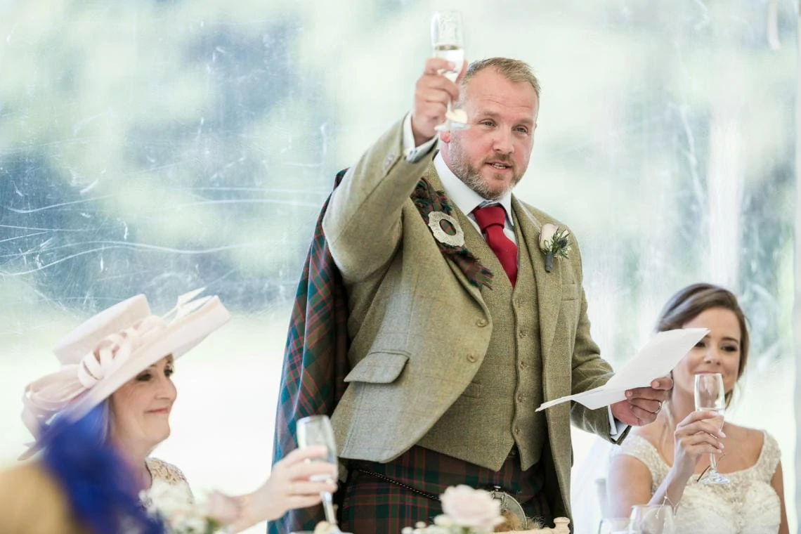 groom raising a toast at the end of his speech