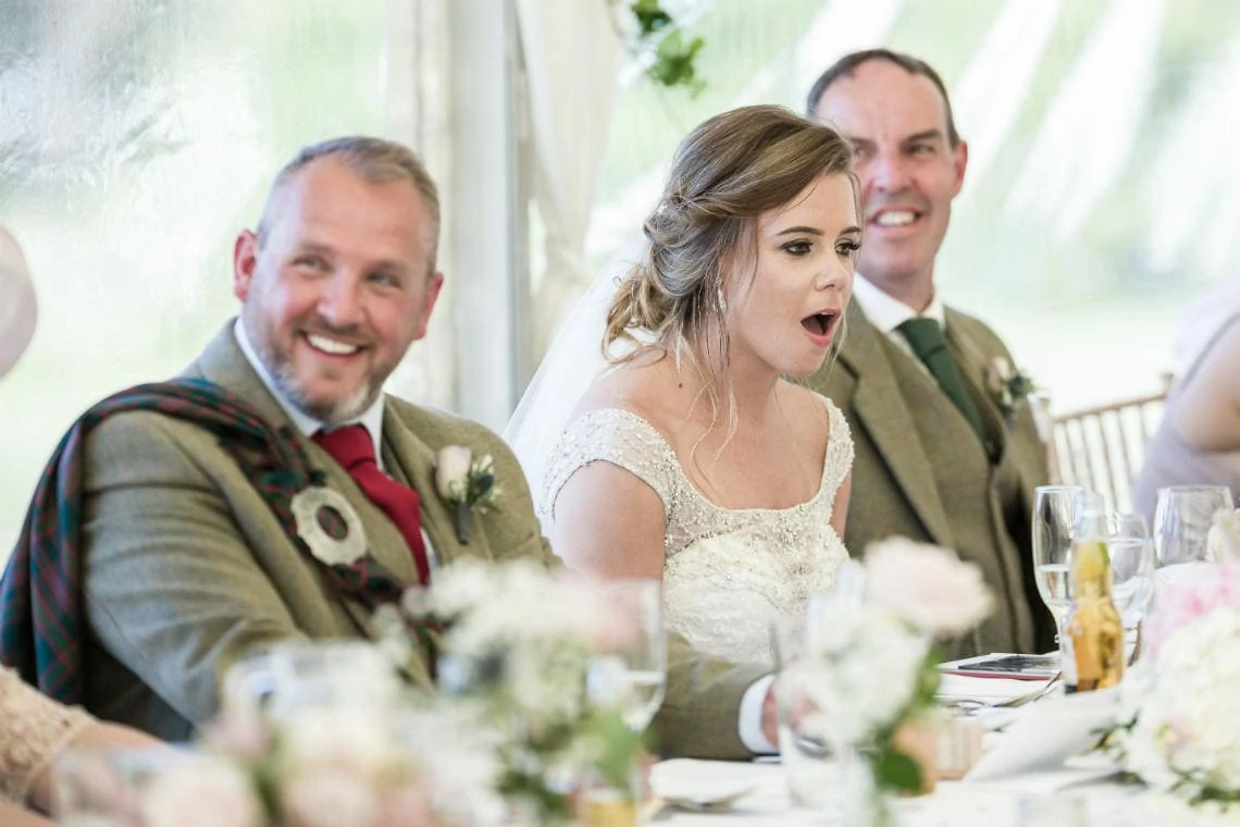 bride looking shocked during best man speech